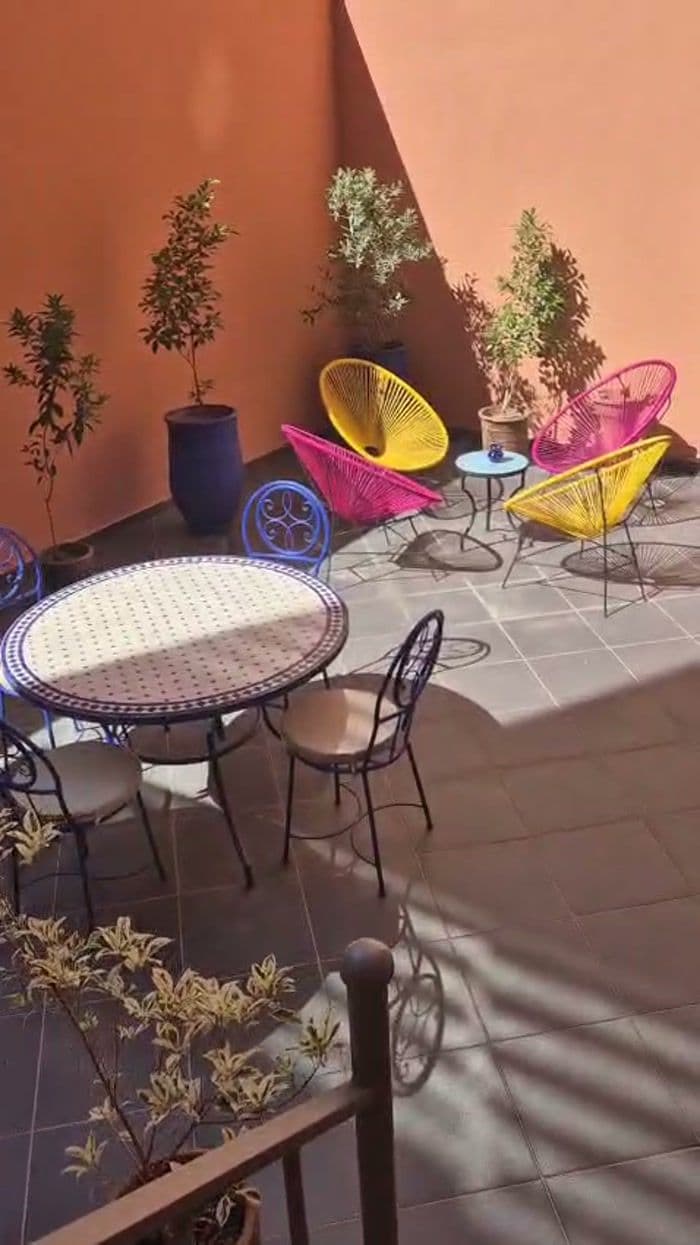 Terrasse privative avec table en mosaïque et assises colorées